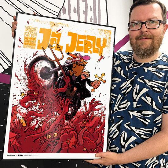 Tomasz Lew Leśniak trzyma plakat z planszą z komiksu Jeż Jerzy - "Apage Satanas!"