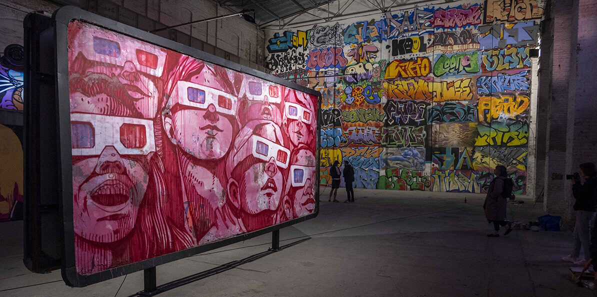 W 2021 roku w monumentalnej hali na terenach postoczniowych w Gdańsku stanął on – billboard „OBEY” autorstwa SEPE. Tłum ludzi. Wszyscy patrzą w tym samym kierunku. Wszyscy mają na nosach okulary 3D. I choć każdy z nich widzi ten sam obraz… każdy widzi go inaczej.
Był to symbol wystawy „Outsiders” – pięcioletniego projektu artystycznego prowadzonego przez galerię Layup. Przez lata hala 94B tętniła kolorami, graffiti, wielkoformatowymi obrazami i uliczną energią. Ale przyszedł moment finału. I nikt nie spodziewał się tego, co wydarzyło się wtedy. W jeden wieczór wszystko zniknęło. Każdy mural, każda praca, każdy szczegół - zamalowane na biało. Jakby nic nigdy tam nie było.
Ten gest nie był przypadkowy. To refleksja nad cyklem życia miejskiej sztuki - która żyje, rośnie, inspiruje… ale też przemija. Jak miasto, które nieustannie się zmienia. I jak pamięć, która zostaje tylko u tych, którzy widzieli.
Dziś wracamy do tej pracy - po latach, w formie kolekcjonerskiego printu. „OBEY” Michała Wręgi (SEPE) dostępny jest teraz w limitowanej edycji. Jako obraz tego, co było. I przypomnienie, że sztuka uliczna - choć chwilowa - może zostać z nami na dłużej.
Ale pamiętaj - nasze printy, tak jak street art z ulic, też znikają. Po wyczerpaniu edycji - nie będzie wznowienia.